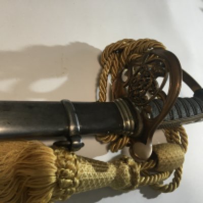 A Victorian officers Cavalry Sword with a brass cross guard with Victorian Cypher bound grip the blade with further ornamentation maker M Stewart Barron in Furness steel scabbard.
