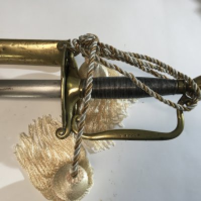 A steel and brass sword with wired grip stamped Nathan with a brass mounted leather scabbard.