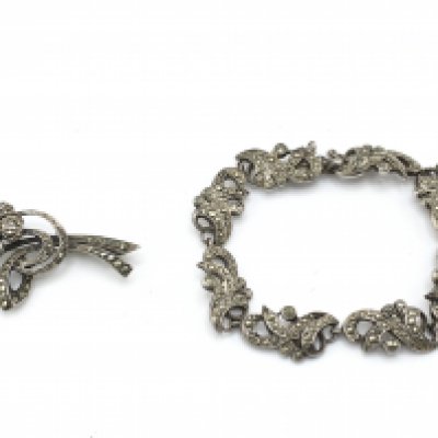 A silver bracelet and a silver brooch set with pearl. Postage B