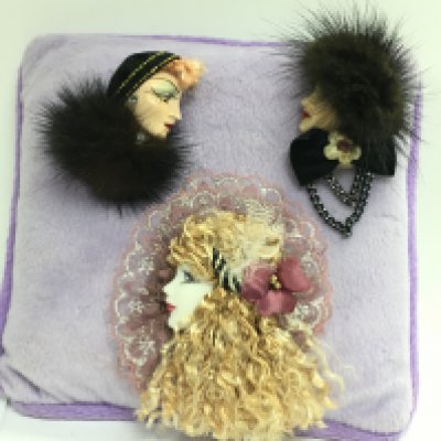 Two mink brooches, lace and feather brooch on cushion. Postage category B