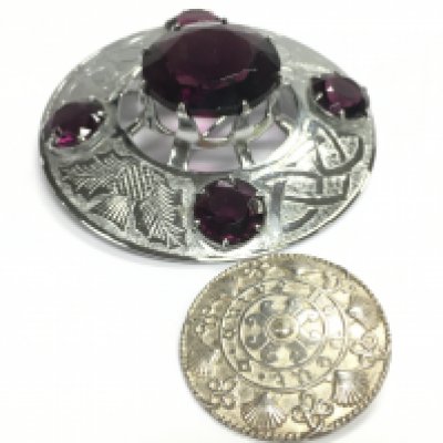 A large Celtic brooch pin and a smaller Celtic brooch. Postage category A