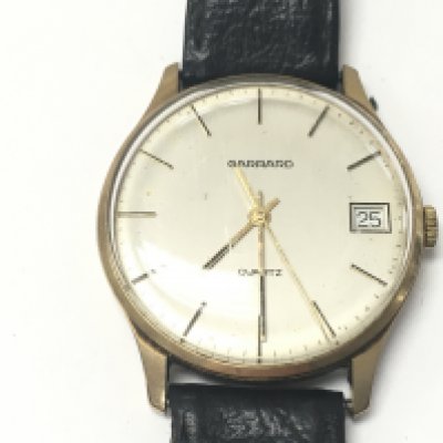 A vintage gents 9ct Garrard wrist watch with leather strap. Not seen running.