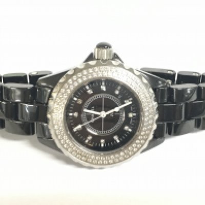 A black Chanel J12 Womens watch set with diamonds.