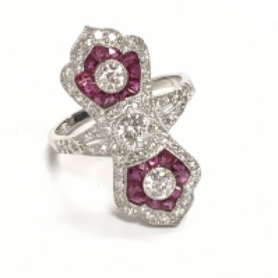 Platinum Edwardian style ruby and diamond pinched design ring. Central old cut diamond and two largerRBC diamonds 0.59ct. Mixed calibre cut rubies 0.35ct. Remaining R/C diamonds 0.80ct. Ring size Approx M. Postage category A.