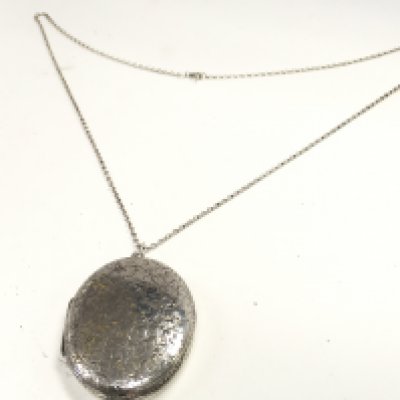 A large silver locket on a silver chain. Postage category a