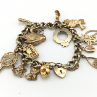 A 9ct gold charm bracelet with multiple charms. 47.40g Postage A