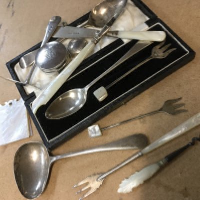 A collection of cutlery including silver with mother of pearl handles, a cased silver tea spoon and mother of pearl notepad