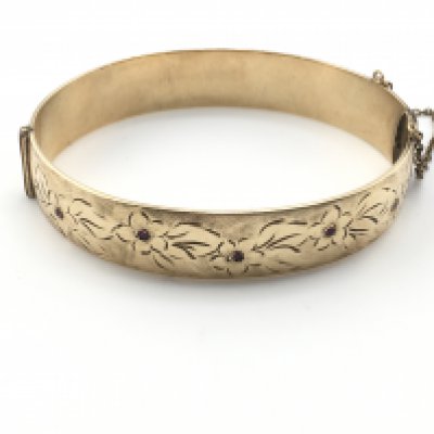 A gold metal core bangle 6.5cm diameter. Postage B