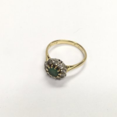 An 18ct gold ring set with diamonds and a green central stone. Approx weight 3.73 grams, size M1/2.