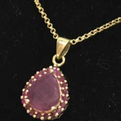 A 9ct gold Rubilite pendant and 9ct gold chain. 4.1g total weight. Postage category A