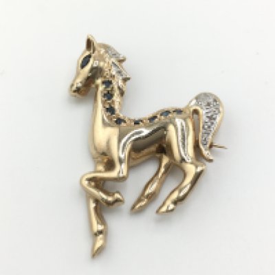 A 9ct gold horse set with sapphires and diamond chips. Approximately 3cm and 6.18g Postage A