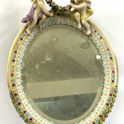 A pair of German porcelain cherub wall mirrors. 34cm x 25.5cm