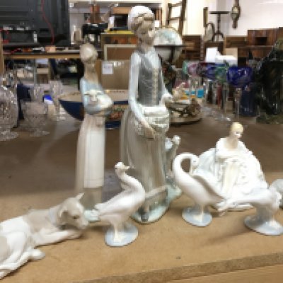 A collection of porcelain Lladro figures including geese , two girls and a cow and a Doulton Joanne HN 2373 figure. This cannot be posted
