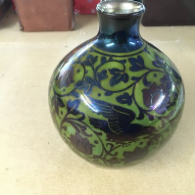 William S Mycock Pilkington Royal Lancastrian lustre base with 2 birds amongst foliage is silver luster with red flowers against a yellow Green ground.  On closer inspection there is a small chip and hairline approximately 2 inches from the top rim to the bottom