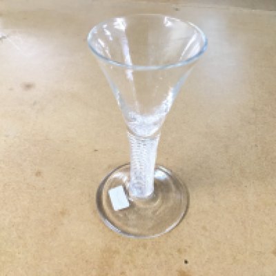An 18th century drinking glass circa 1750 a drawn trumpet bowl above an air twist stem rasied to a circular spread foot. 13cm tall. Good condition with no obvious damage.