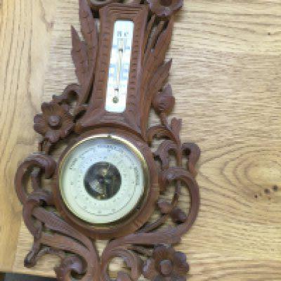 A small oak Black Forest carved wall barometer.