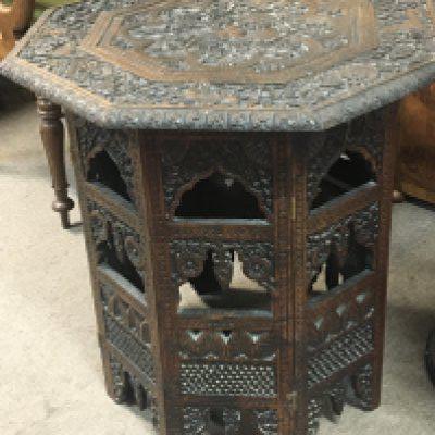 A late 19th century carved hardwood octagonal top card table with both Indian and Middle Eastern influence.