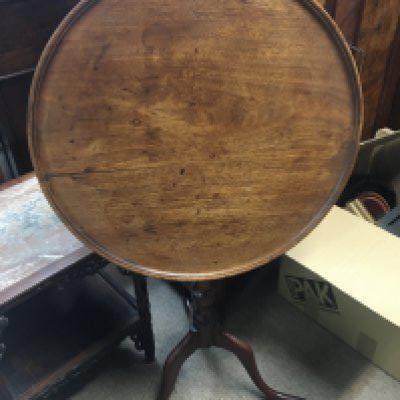 A George III mahogany tip action wine table with a circular top on a turned column. top diameter 49cm