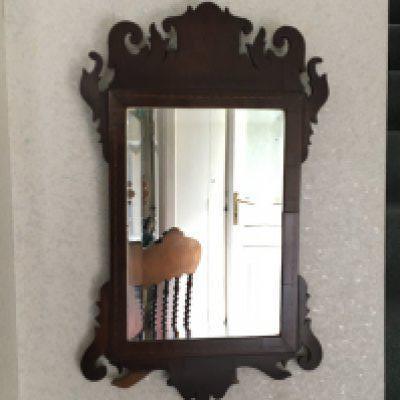 A George III wall mirror with pierced scroll cresting and of rectangular shape. 51x31cm