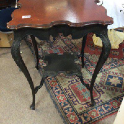 An Edwardian walnut occasional table with a shaped top and legs United bu an under shelf.