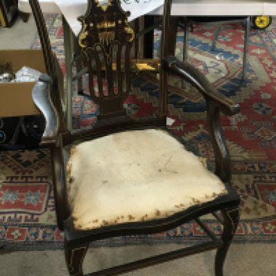 An Edwardian inlaid open arm chair with a shaped top rail and inlaid back.