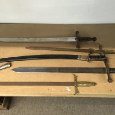 A collection of replica swords including an Indian sword, replica Roman style swords etc
