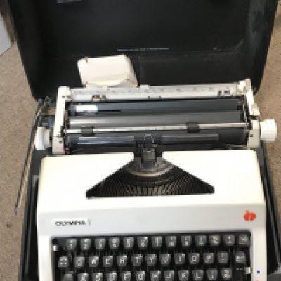 A Cased vintage Olympia typewriter. Postage category C