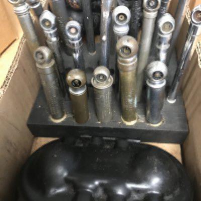 Two small wooden stands holding 20 vintage tyre pressure gauges and 2 car bulb holders