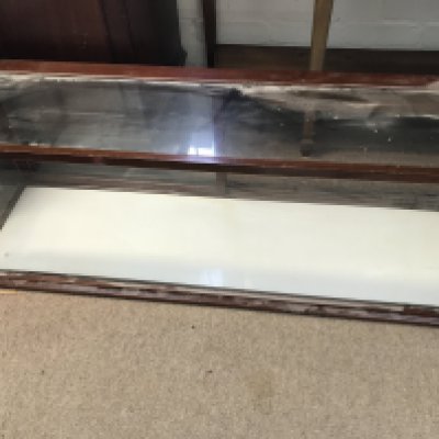 A table top display cabinet with two sliding doors ( no shelves) . 110 cm 30 cm .