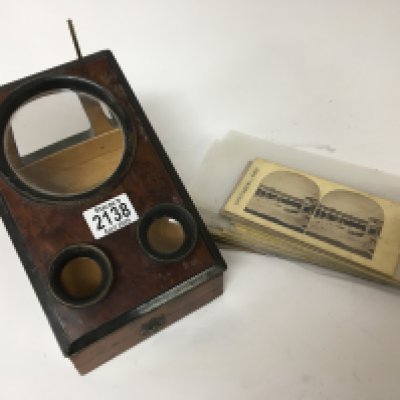 A Victorian walnut 3D viewer with a collection of viewing cards,