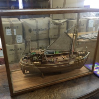 A scratch built detailed wood model of an off shore fishing boat in sail in a glass case. 65x50cm