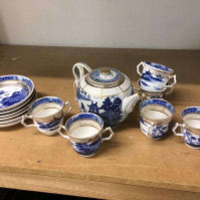 A Chinese 18th century Tea set decorated with lakeside pagodas in underglaze blue. Featuring plates, twin handled cups and a (damaged and restored) tea pot. This lot cannot be posted