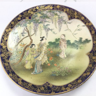 A Japanese Satsuma dish decorated with traditional figures in nature and a cobalt blue glaze underside. Dish 19cm wide