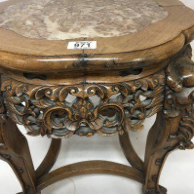 A Quality Chinese hardwood jardiniere stand with a shaped top inset with marble carved apron the legs with raised masks and ball and claw feet. Height 46cm.