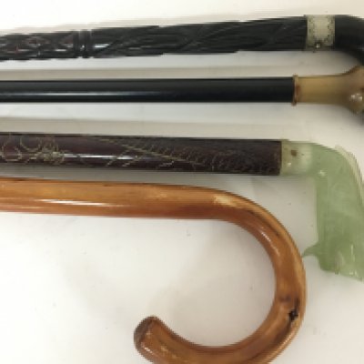 A Chinese walking stick with carved jade top in the form of a stylised dragon and three other walking sticks (4)