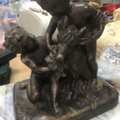 A bronze classical figure group depicting cherubs and goat .