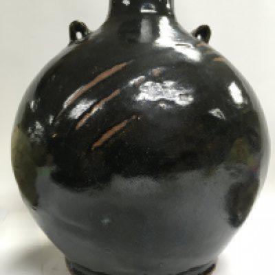 A collection of stone ware art pottery comprising twin handle blue and black glazz vase 30 cm Two stone ware vase with celadon glazz 20 cm a black glazz circular tray 30 cm and a small David Leach Dish .