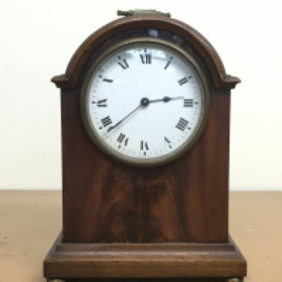 A small mahogany Edwardian mantle clock with brass handle and enamel dial, this lot cannot be posted
