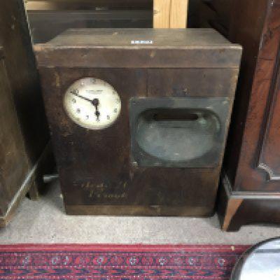 A small cased clocking in clock.