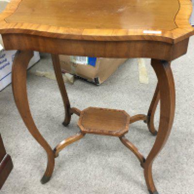 An Edwardian occasional table the shaped top with a cross banded edge on shaped legs.