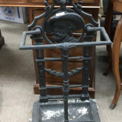 A cast iron stick stand the back the frame decoration incorporating a side profile.
