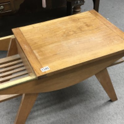 A modern design teak occasional table with a sliding top above shelves on splayed legs.