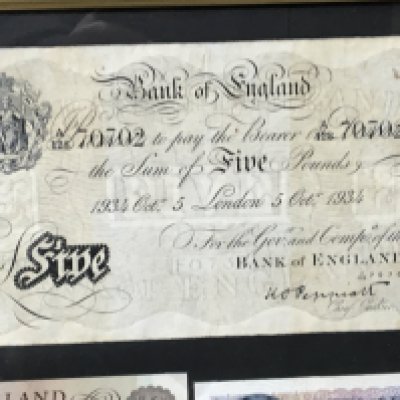 Three frames containing British bank notes including a 1934 white five pound note.