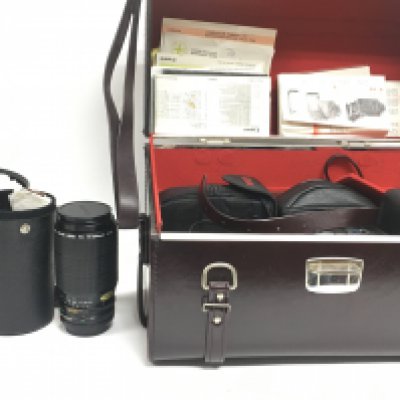 A Collection of vintage camera equipment including a Painz Saturn 35 Auto camera, Canon A-1, Canon 200mm zoom lens. Postage category C