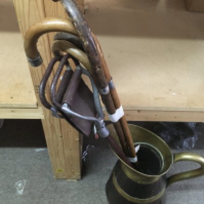 A large brass bound wooden jug with hallmarked silver rimmed walking sticks and a shooting stick