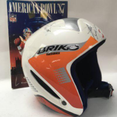 A singed American football helmet together with a official program Los Angeles Rams v Denver Broncos .