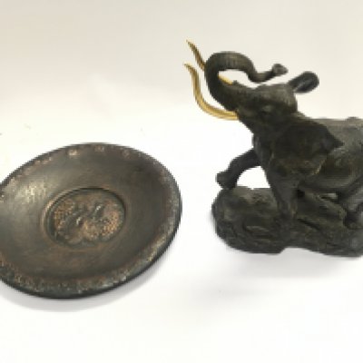 A bronze elephant with a hanging presentation plate.
