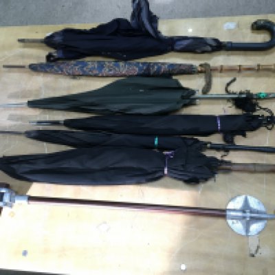 A collection of vintage umbrellas and a seat stick. Postage D