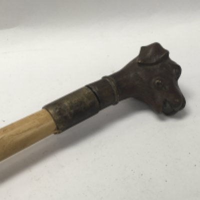 A sword stick the bronze handle in the form of a dogs head .