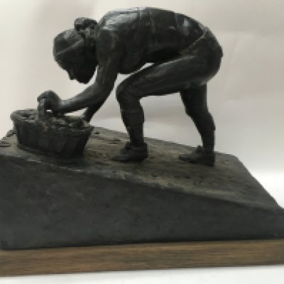 A bronze figure the Harvest sculptor by Archie Forrest on an oak plinth base . 28 cm .
